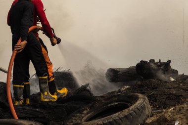İtfaiyeciler yangına su hortumu kullanarak