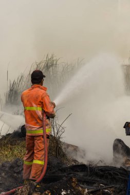 İtfaiyeciler yangına su hortumu kullanarak
