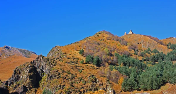 Panorama van de bergen met Gergets kerk (Tsminda Sameba) in de buurt van het dorp Kazbegi (Georgia) — Gratis stockfoto