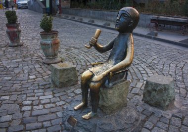 Tiflis - 16 Aralık 2017. Tamada ile şarap boynuz eski Tiflis, Georgia.Tamada Sioni'nın sokakta oturan bronz heykel bir Gürcü toastmaster adlı bir Gürcü Supra (Bayramı olduğunu).