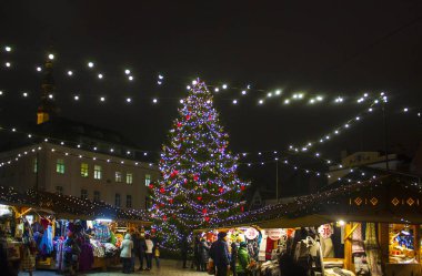 Tallinn, Estonya - 3 Ocak 2018: Belediye Meydanı (Raekoja plats) Tallinn kış pazarının tam olarak, ön planda ışıklı Noel ağacı ile tezgahları