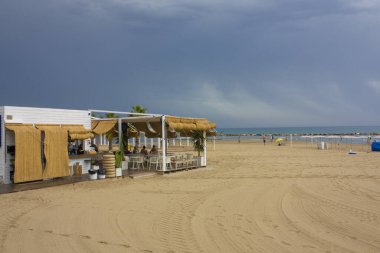 İspanya 'nın Alicante kentinde mavi deniz ve sahil kenarında bir kafe manzarası