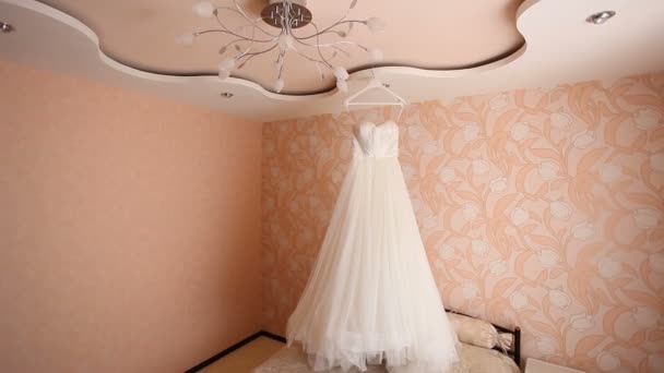 Vestido de novia blanco colgando en la habitación rosa — Vídeos de Stock