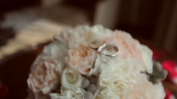 Wediing rings lying on the bouquet — Stock Video