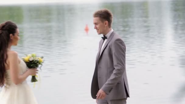 Bräutigam kommt zur Braut und küsst sie — Stockvideo
