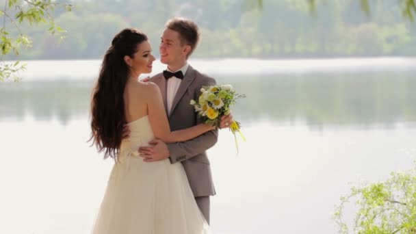 川の背景で話している新婚夫婦 — ストック動画