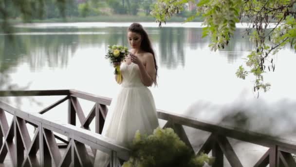 Sposa in piedi sul molo del fiume — Video Stock