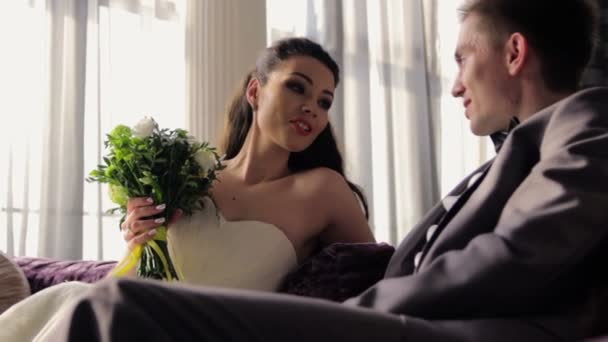 Kanepede oturan ve konuşurken yeni evliler — Stok video
