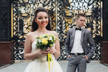 Gelin buketi ve arka planda damat ile