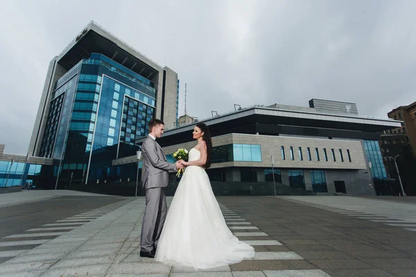 Newlyweds in front of the high blue building — Stock Photo, Image