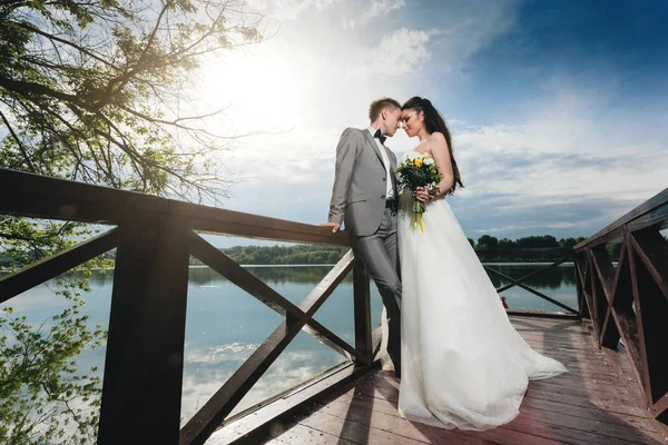 Jonggehuwden permanent op de pier van de rivier — Stockfoto