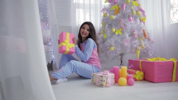 Pige på hvidt tæppe åbning gaver – Stock-video