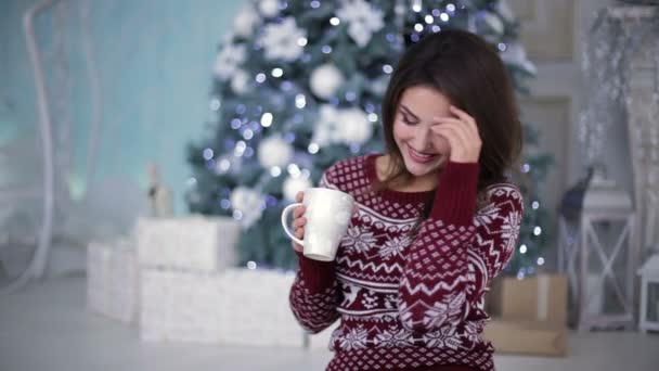 Fille en pull lumineux devant sapin — Video