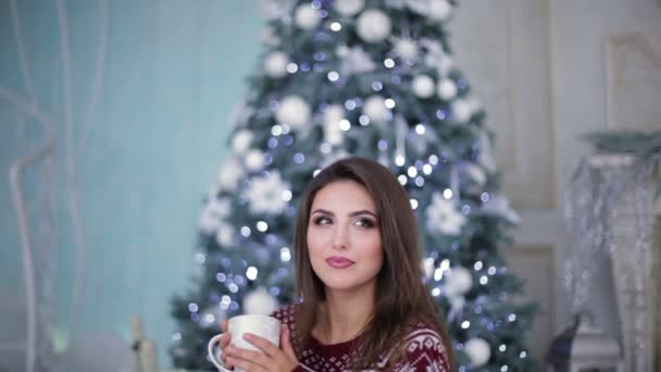 Vacker modell med kopp nära julgran — Stockvideo