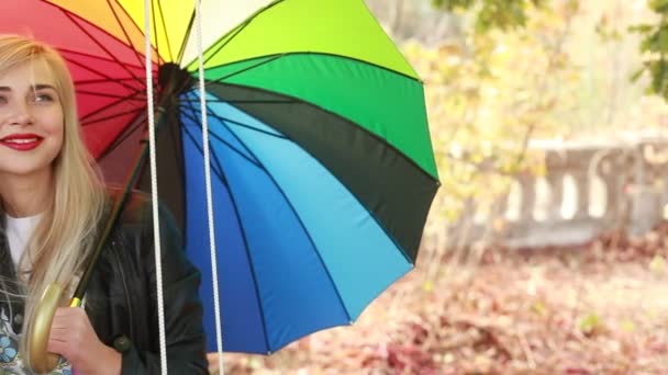 Молодая девушка с зонтиком на качелях — стоковое видео