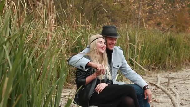 Посміхаючись закохана пара на березі річки — стокове відео