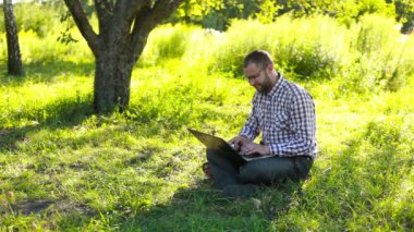 Laptop alanında yazarak ve cam içine bakarak mutlu adam