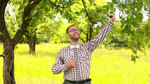 Jonge man in glazen selfie maken in de weide — Stockvideo