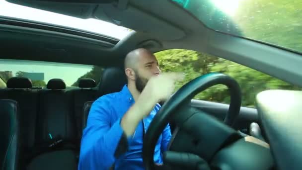 Jovem macho com barba canta e dança durante a condução — Vídeo de Stock