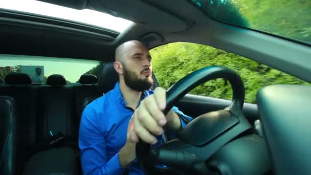 Young man with beard sings and dances during driving — Stock Video