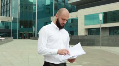 Belgelerle tişörtlü adam