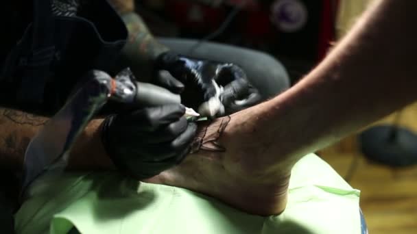 Med en maskinpark gör mästaren tatuering — Stockvideo