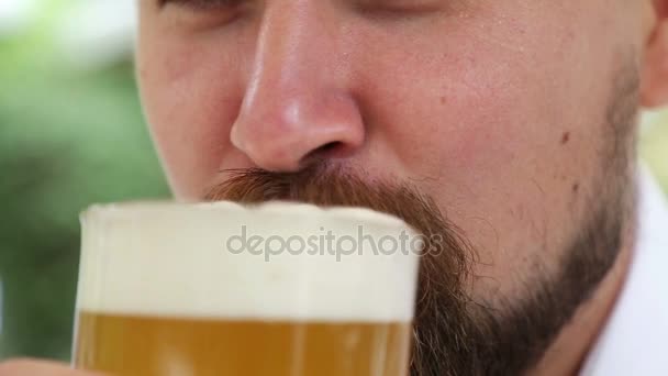 Man met schuim op de neus en snor bier drinken — Stockvideo