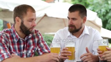 Üç adam bira ile kafede oturan ve fotoğraf yapma sakallı