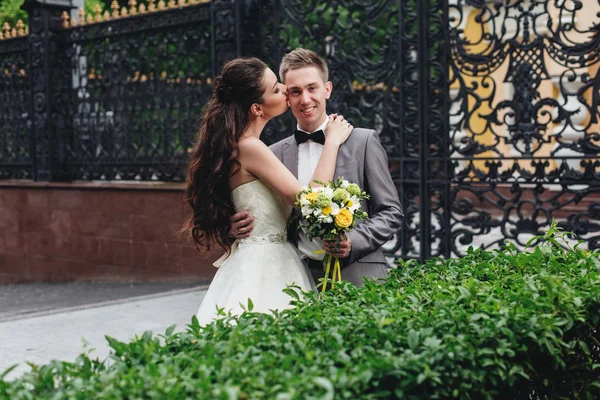 Невеста целует своего улыбающегося жениха — стоковое фото