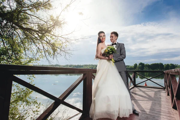 Groom olhando para sua noiva no cais do rio — Fotografia de Stock