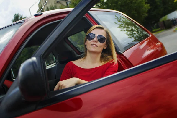 Meisje in een rood shirt en een rode auto rijden — Stockfoto