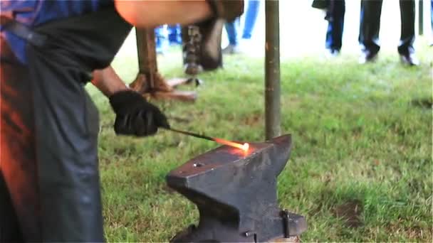 Досвідчений коваль нагріває метал і корів розплавленого металу на ковадлі в ковалі . — стокове відео
