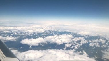 Dünya ve uçuş sırasında uçağın kanatları altına beyaz bulutlar