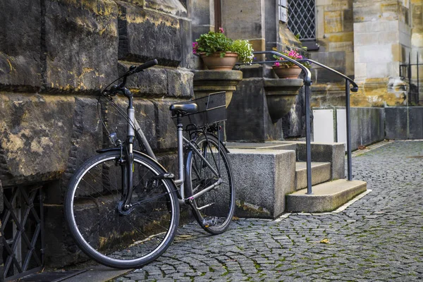 Textur aus Stein und Kopfsteinpflaster, Fahrrad auf einer Stadtstraße — Stockfoto