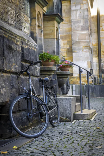 Textur aus Stein und Kopfsteinpflaster, Fahrrad auf einer Stadtstraße — Stockfoto