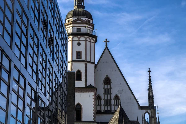 En modern byggnad framför kyrkan av St Thomas i Leipzig. Johann Sebastian Bach arbetade här från 1723 fram till sin död — Stockfoto