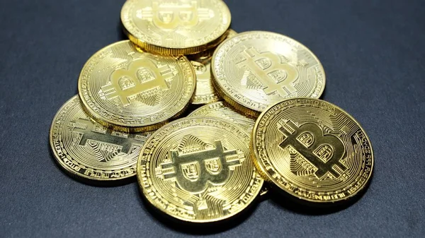 Kilka monet złota bitcoinów na ciemnym tle — Zdjęcie stockowe