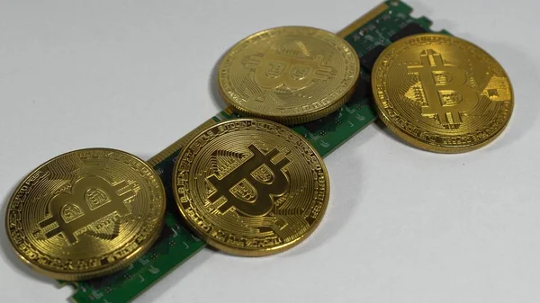 Kilka monet bitcoinów i pas elektroniczny pamięci na jasnym tle — Zdjęcie stockowe