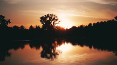 Ormana yakın göl üzerinde güzel doğal gün batımı. Timelapse