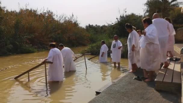 Jordan River, Israel - November, 2019: Pilgrims and tourists on the banks of the Jordan River. — Stock Video