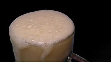 Light bira ve köpük - dökme yakın çekim, siyah arka plan