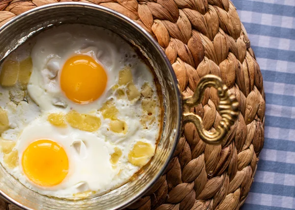 Sunny side up eggs with cheese, breakfast served in copper pan — Stock Photo, Image