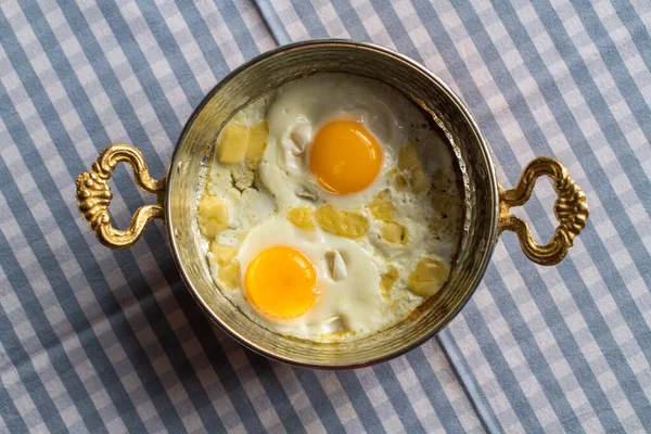 Sunny side up eggs with cheese, breakfast served in copper pan — Stock Photo, Image