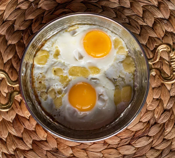 sunny side up eggs with cheese, breakfast served in copper pan