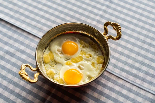 sunny side up eggs with cheese, breakfast served in copper pan