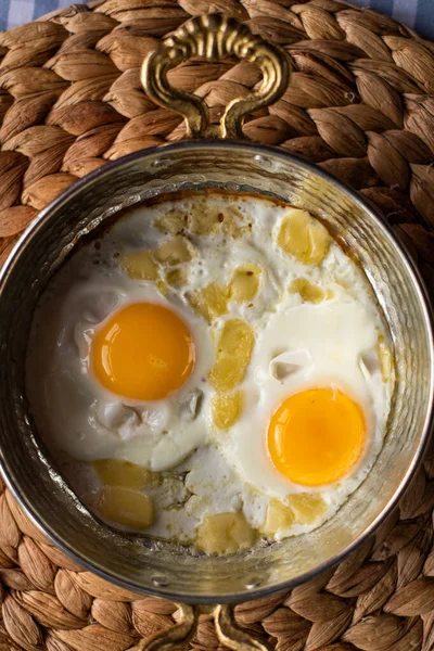 Sunny side up eggs with cheese, breakfast served in copper pan — Stock Photo, Image