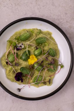 Avokado mus kabak ve mikro yeşilliklerle servis edilir. Sağlıklı vejetaryen yemekleri