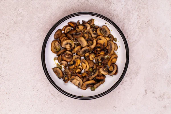 Vegan food. Baked mushrooms served with capers and garlic