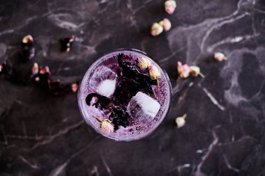 Hibiscus ve kurumuş gül tomurcuklarıyla Pembe Cin ve Tonik kokteyli.