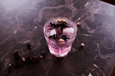 Hibiscus ve kurumuş gül tomurcuklarıyla Pembe Cin ve Tonik kokteyli.